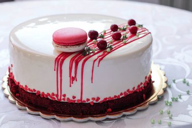 Kırmızı meyveler ve macaron tarafından dekore edilmiş lezzetli beyaz ev yapımı kek. Modern fotoğraf.