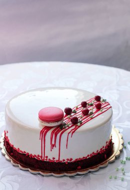 Kırmızı meyveler ve macaron tarafından dekore edilmiş lezzetli beyaz ev yapımı kek. Modern fotoğraf.
