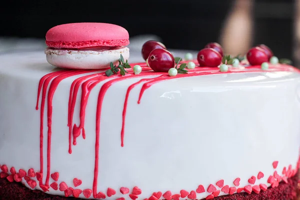 Kırmızı meyveler ve macaron tarafından dekore edilmiş lezzetli beyaz ev yapımı kek. Modern fotoğraf.