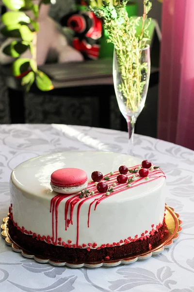 Kırmızı meyveler ve macaron tarafından dekore edilmiş lezzetli beyaz ev yapımı kek. Modern fotoğraf.