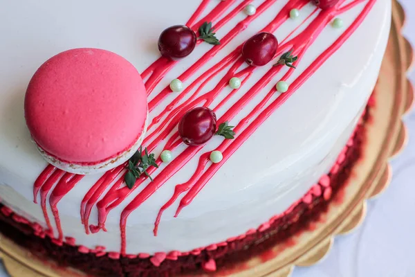 美味的白色自制蛋糕 由红色浆果和马卡龙装饰 现代照片 — 图库照片