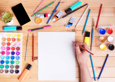 Resim ve çizim için bir model. Kalemi tutan ve beyaz kağıda çizen eller. Yukarıdan görüntüle.