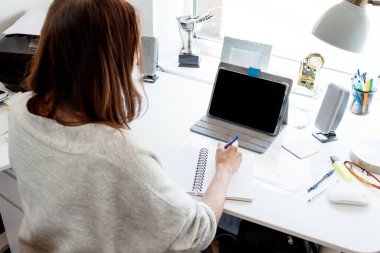 Evde internet tabletinde çalışan bir kadın. 