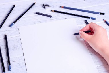 Çizim için hazırlan. Sıkıştırılmış kömürle çizilen eller. Birkaç kalem ve siyah sıkıştırılmış kömür. Yukarıdan görüntüle.