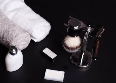 Siyah arka planda jilet, fırça, bıçak ve havlular.