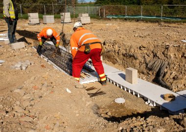 Bahçıvan bir ev için dahili drenaj kuruyor..