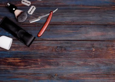 Ustura, fırça, parfüm, balsam ve siyah arka planda tıraş köpüğü..