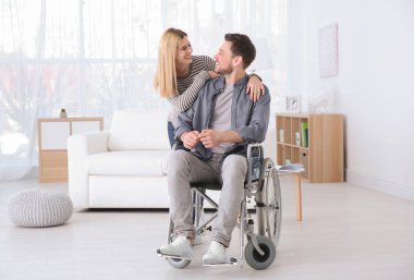 Genç kadın adam kapalı tekerlekli sandalyede Bakımı