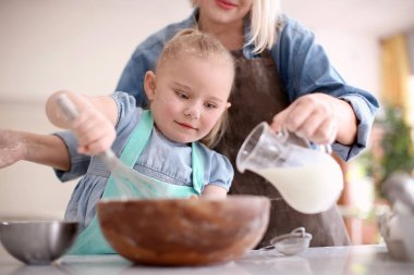 Küçük kız ve büyük annesi mutfakta birlikte hamur hazırlama