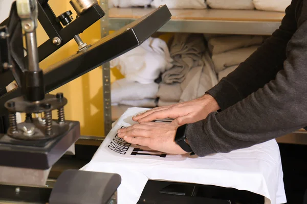 man printing on t-shirt at workshop