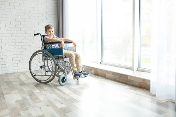 Мальчик в инвалидной коляске в помещении — стоковое фото