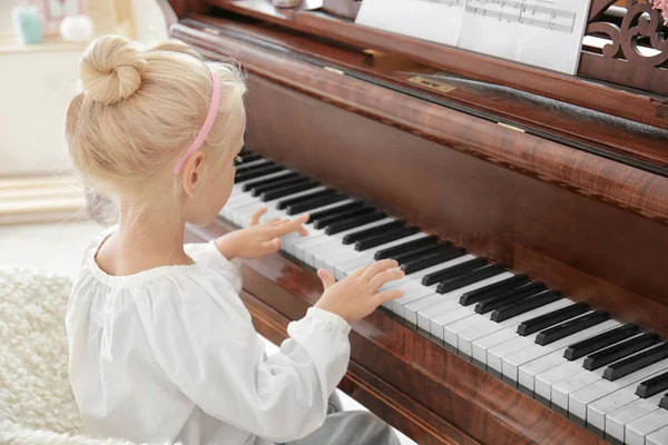 Liten flicka spela piano inomhus — Stockfoto