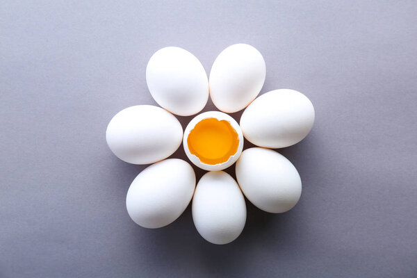 Flower made of raw chicken eggs on color background