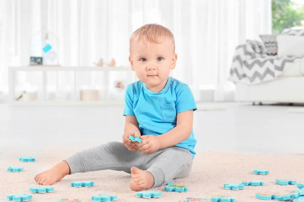 Cute little boy playing with puzzle at home — Stock Photo, Image