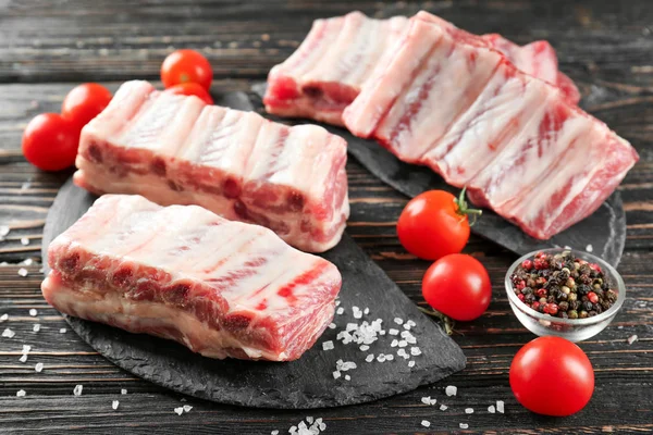 Ahşap masa üzerinde taze Çiğ domuz kaburga ile kayrak plaka
