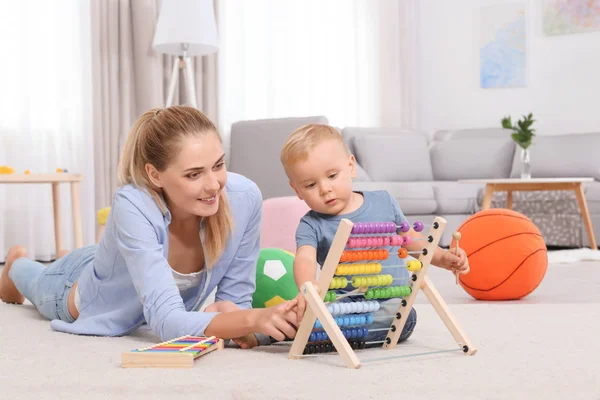 Evde oyuncak abacus ile oynarken anne ve bebek — Stok fotoğraf