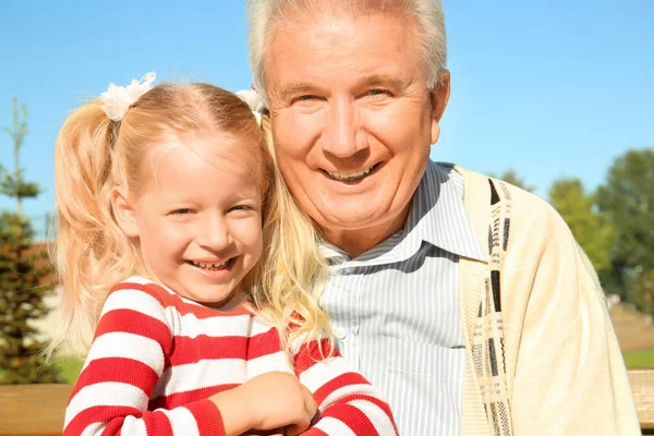 Oudere man met kleindochter in park — Stockfoto