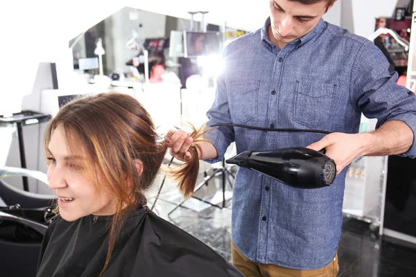 Estilista profesional de secado por soplado cabello de mujer en el salón —  Fotos de Stock