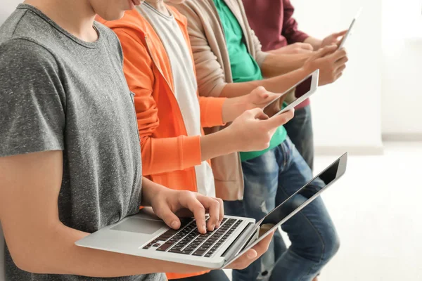 Group of teenagers with modern devices indoors — Stock Photo, Image