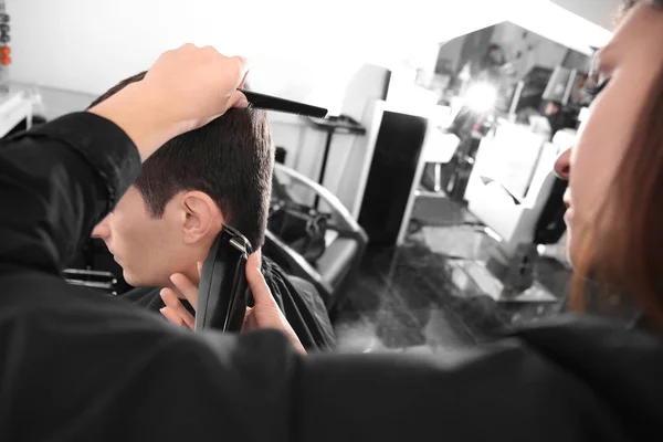 Профессиональный стилист стрижет волосы клиента в салоне, крупным планом — стоковое фото