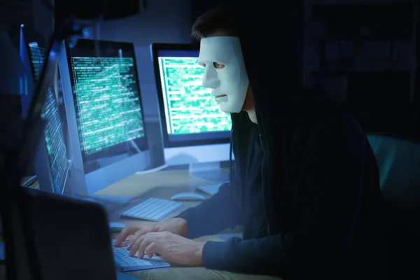 Hacker enmascarado usando ordenador — Foto de Stock