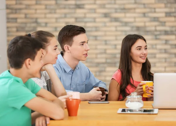 Grupo de adolescentes guays con dispositivos modernos descansando en la cafetería — Foto de Stock