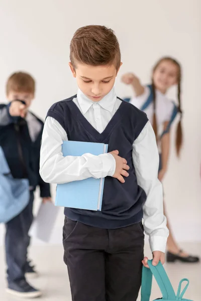 Los niños intimidando a su compañero de clase en el fondo claro —  Fotos de Stock