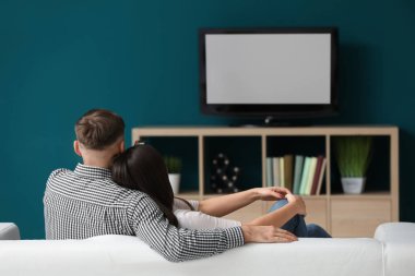 çift evde televizyon izliyor.