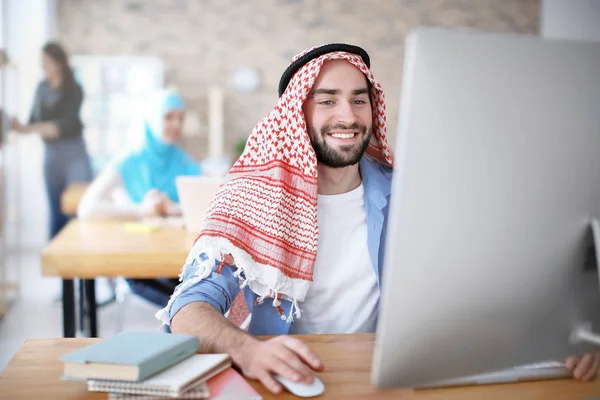 Muslimsk mann i tradisjonelle klær studerer innendørs – stockfoto