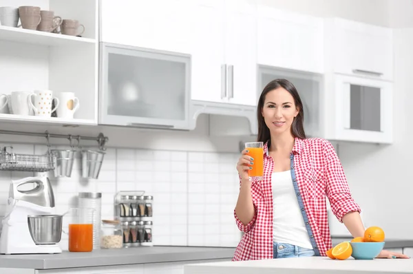 Женщина со стаканом апельсинового сока — стоковое фото