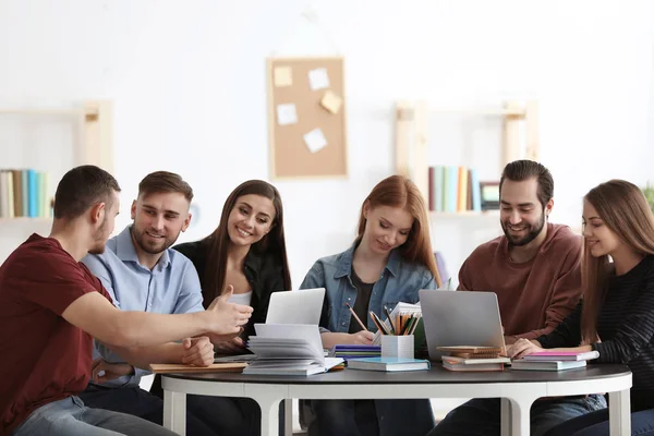 Estudiantes haciendo deberes juntos en la biblioteca — Foto de Stock