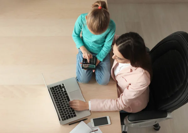 Jeune femme occupée avec sa fille au bureau à la maison — Photo