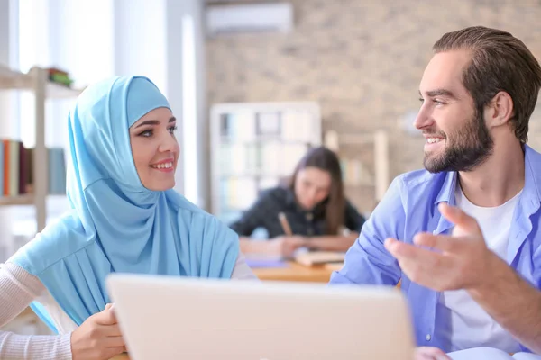 Murid laki-laki dan teman sekelas Muslimnya menggunakan laptop di perpustakaan — Stok Foto