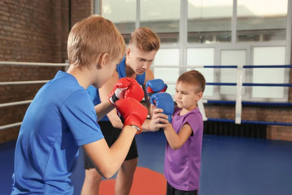Niños pequeños con entrenador en el ring de boxeo — Foto de Stock