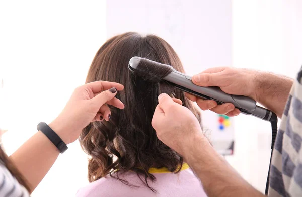 Professioneller Friseur und Auszubildender, der mit dem Kunden im Salon arbeitet. Ausbildungskonzept — Stockfoto