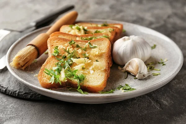 Тарелка с вкусным домашним чесночным хлебом на столе — стоковое фото