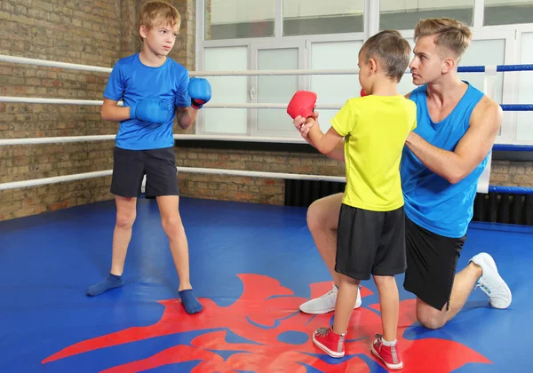 Små pojkar med tränare på boxningsring — Stockfoto