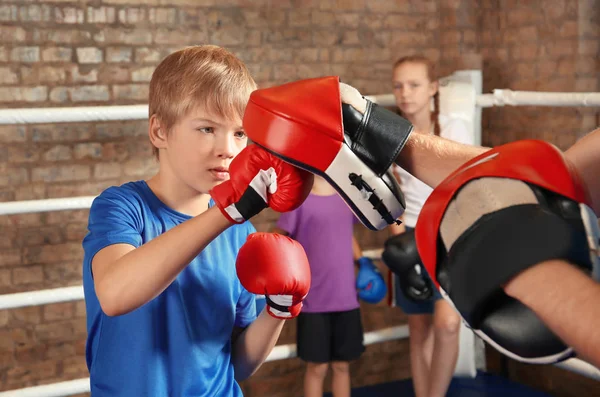 Liten pojke med tränare på boxningsring — Stockfoto
