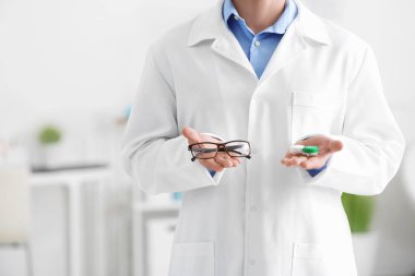Erkek doktor kontakt lens durumda ve gözlük, holding