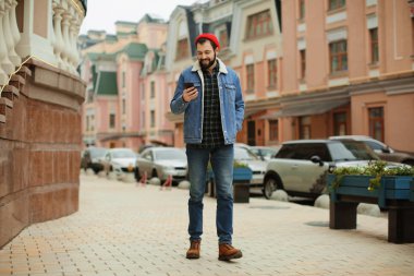 Açık havada cep telefonuyla yakışıklı trendy hipster