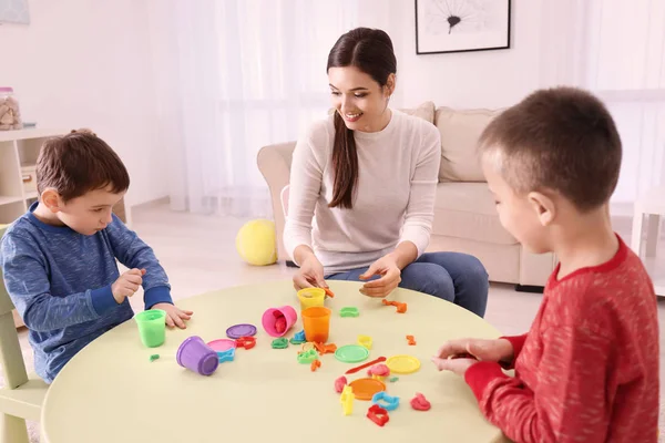 Nanny en jongens beeldhouwen van plasticine — Stockfoto