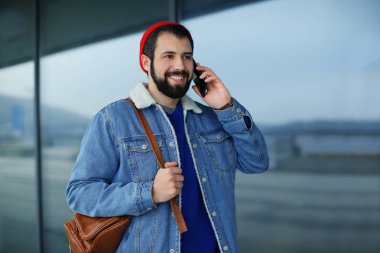 Cep telefonu açık havada üzerinde konuşurken yakışıklı trendy hipster