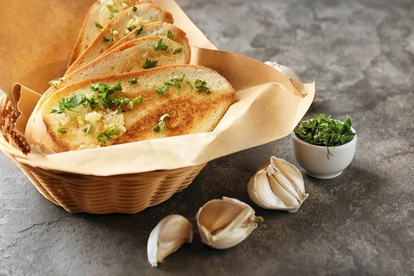Basket with delicious homemade garlic bread on table