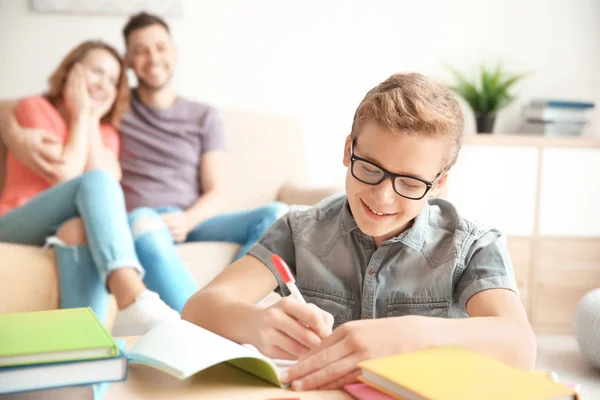 Adolescente Haciendo Tarea Mientras Los Padres Sientan Sofá Casa — Foto de Stock