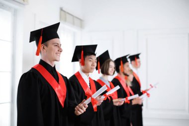 Öğrencilerin diploma kapalı ile lisans cüppeli. Mezuniyet günü