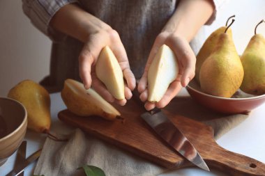 Genç kadın masada taze armut dilimleri ile
