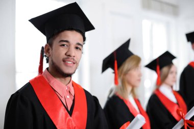 Öğrenci Lisans elbise kapalı diploması ile içinde. Mezuniyet günü