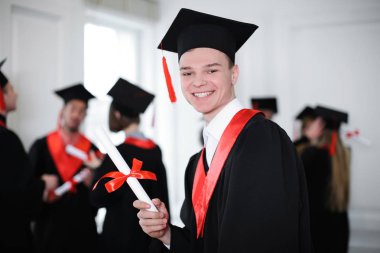 Mutlu Öğrenci Lisans elbise kapalı diploması ile içinde. Mezuniyet günü