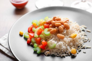 Brown rice with vegetables on plate, closeup clipart