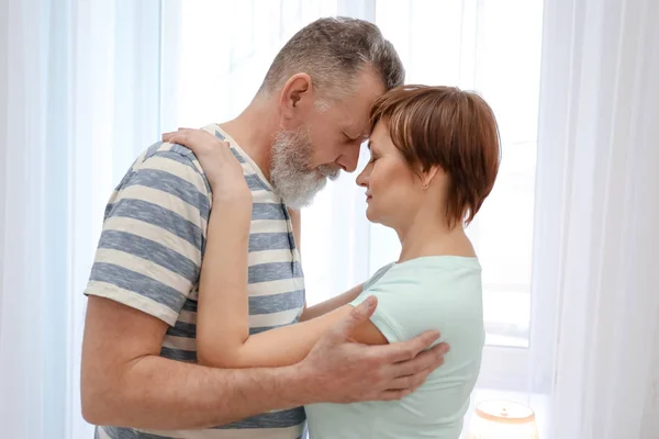 Happy mature couple dancing at home